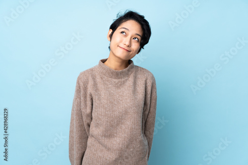 Young Vietnamese woman with short hair over isolated background thinking an idea while looking up