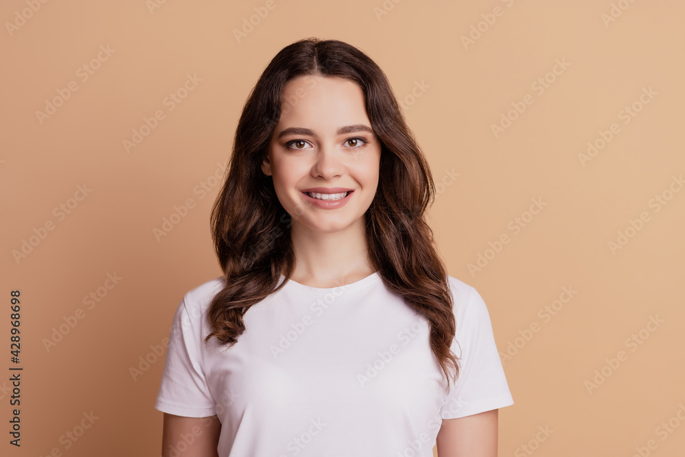 Obraz premium Portrait of young charming girl beaming smile isolated on beige background