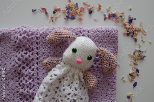 cadeau de naissance : peluche lapin fait au crochet, blanc et multicolore, sur une couverture violette
