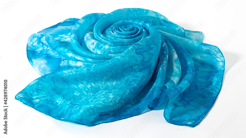 Light blue silk fabric folded in a shape of the flower. Isolated silk decoration on a white background.