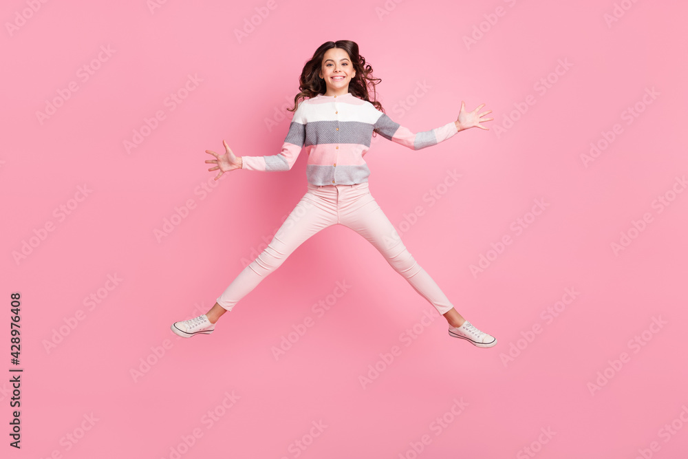 Full body photo of active happy charming girl jump up air good mood weekend isolated on pink color background Full body photo of active happy charming girl jump up air good mood weekend isolated on pink color background