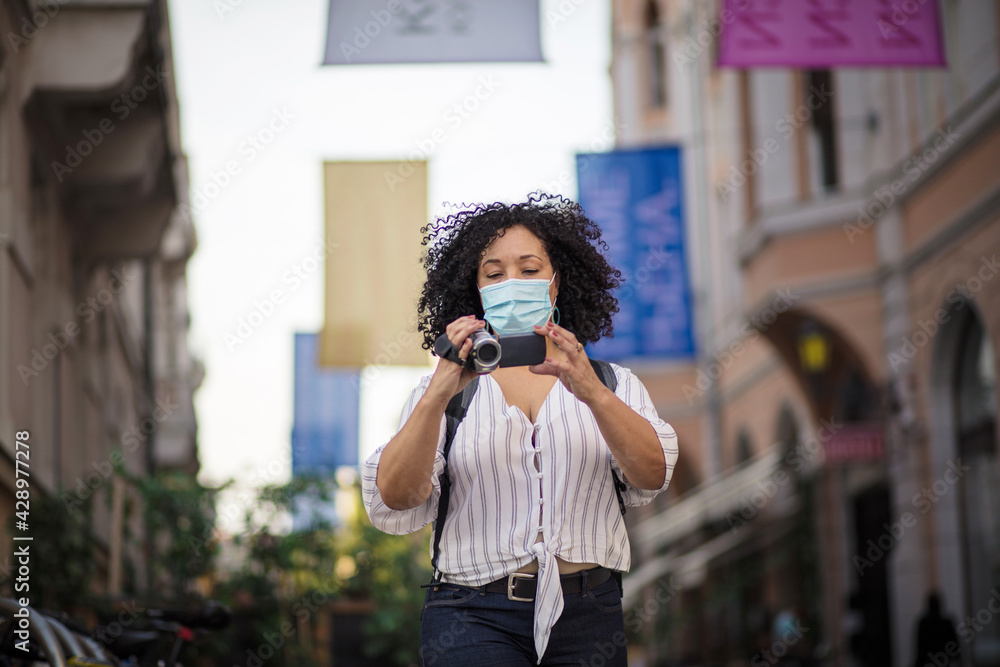 Woman recording on street. Woman with face mask in the street. Woman recording on street. Woman with face mask in the street.