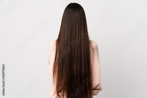 Young Chinese girl over isolated white background in back position