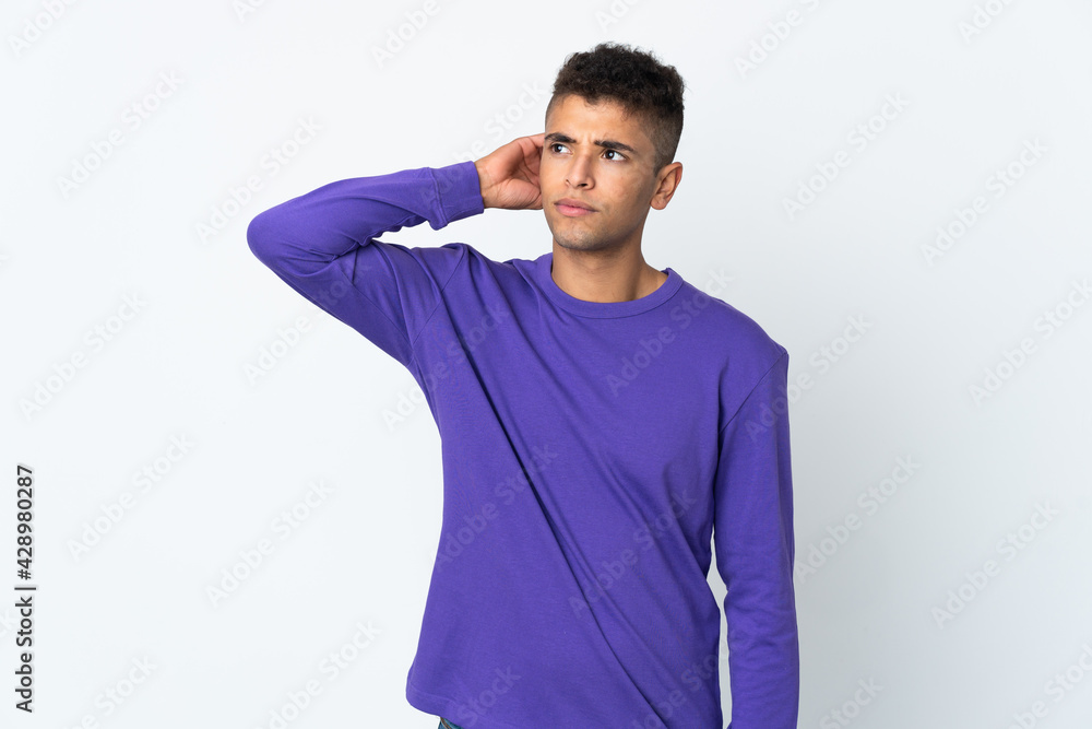 Young brazilian man isolated on white background having doubts Young brazilian man isolated on white background having doubts