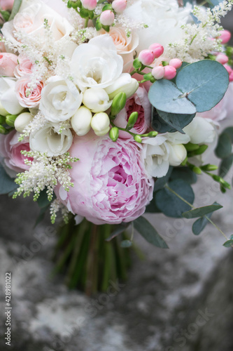 Pink wedding bouquet  composed of roses  freesias  peonies  hypericum  astilba and eucalypthus. Close up.
