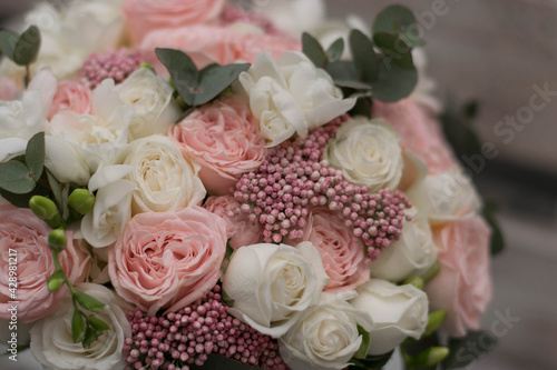 Pink wedding bouquet, composed of roses, freesias, and eucalypthus. Close up.