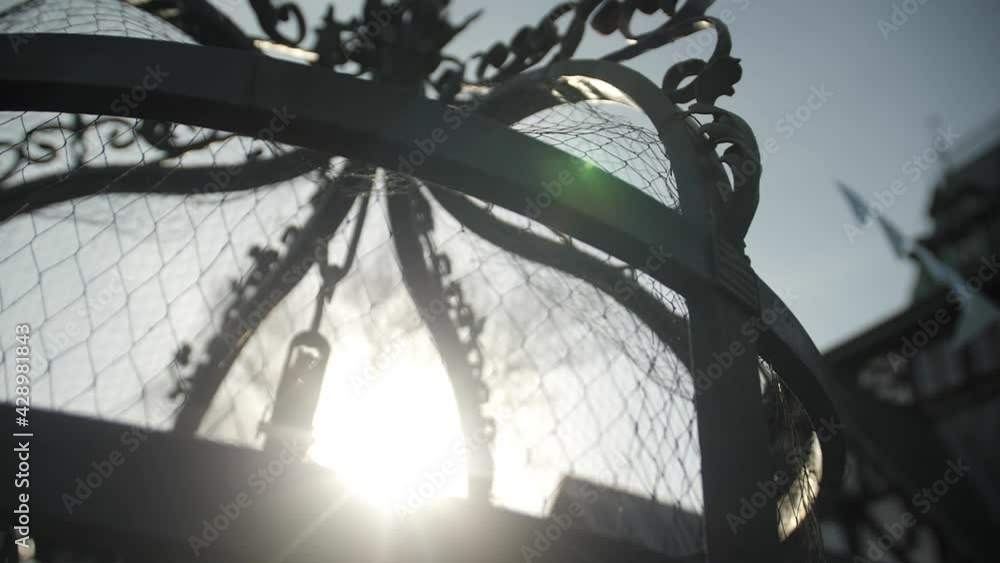 A ray of the sun through the netting. The sun at its zenith shines into the lens. Fence in sunlight. Metal spider web and sunbeam. Dawn in the yard. Playground close up. Slow motion on a metal fence. A ray of the sun through the netting. The sun at its zenith shines into the lens. Fence in sunlight. Metal spider web and sunbeam. Dawn in the yard. Playground close up. Slow motion on a metal fence.