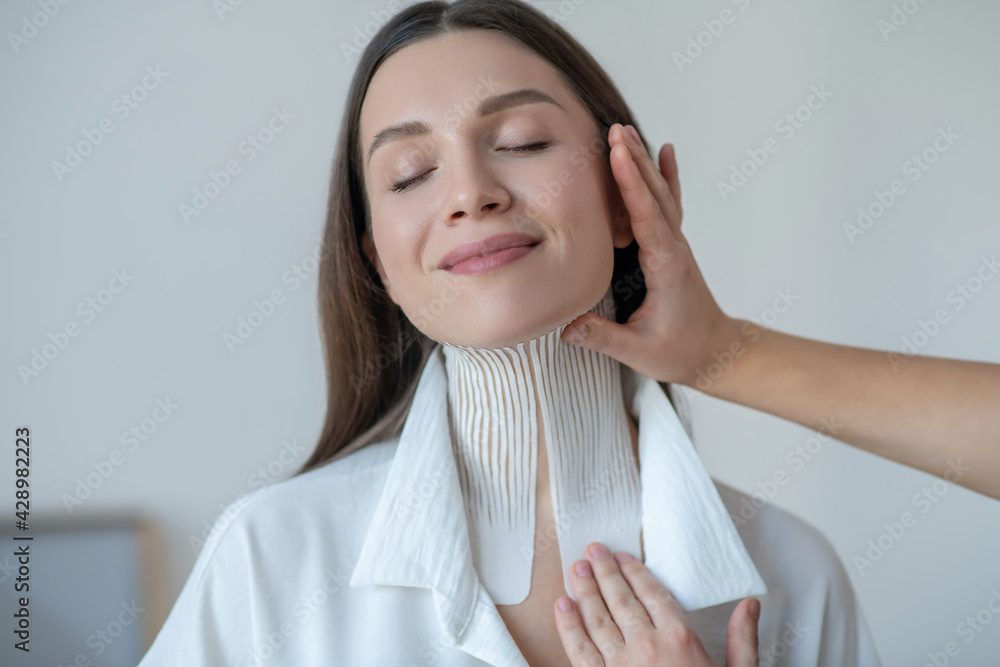 Cute young woman visiting beauty center and looking contented Cute young woman visiting beauty center and looking contented