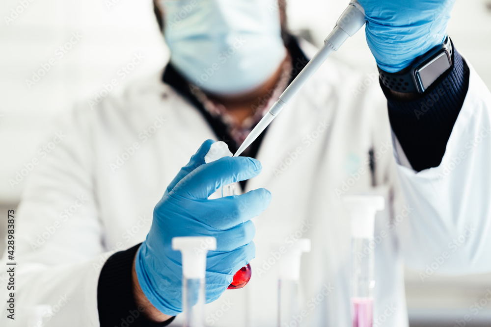 laboratory technician using a pipette with liquid laboratory technician using a pipette with liquid