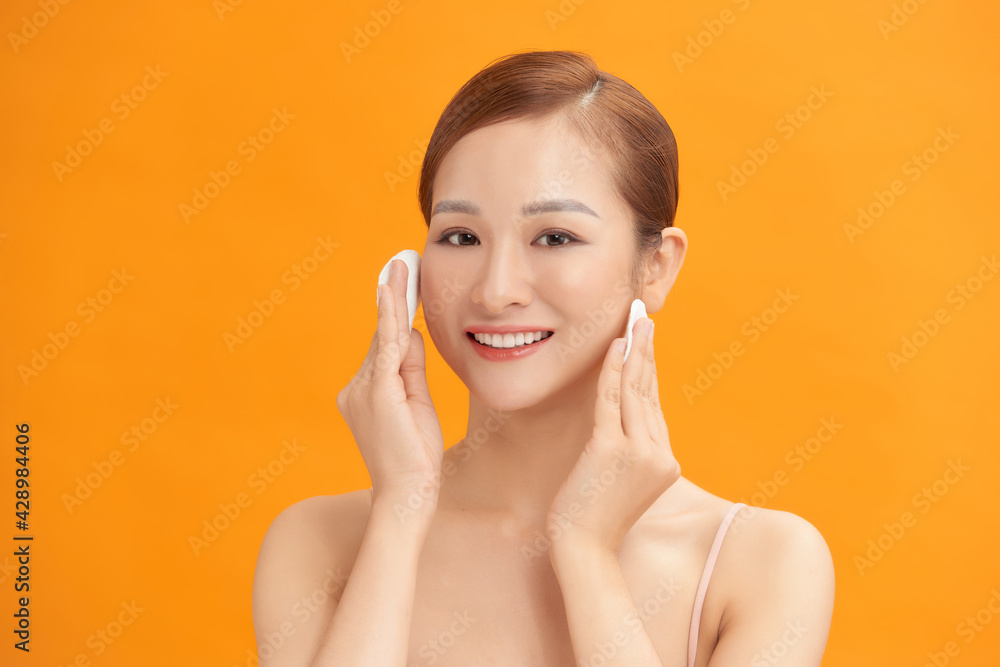 Happy smiling beautiful asian woman using cotton pad cleaning skin Happy smiling beautiful asian woman using cotton pad cleaning skin