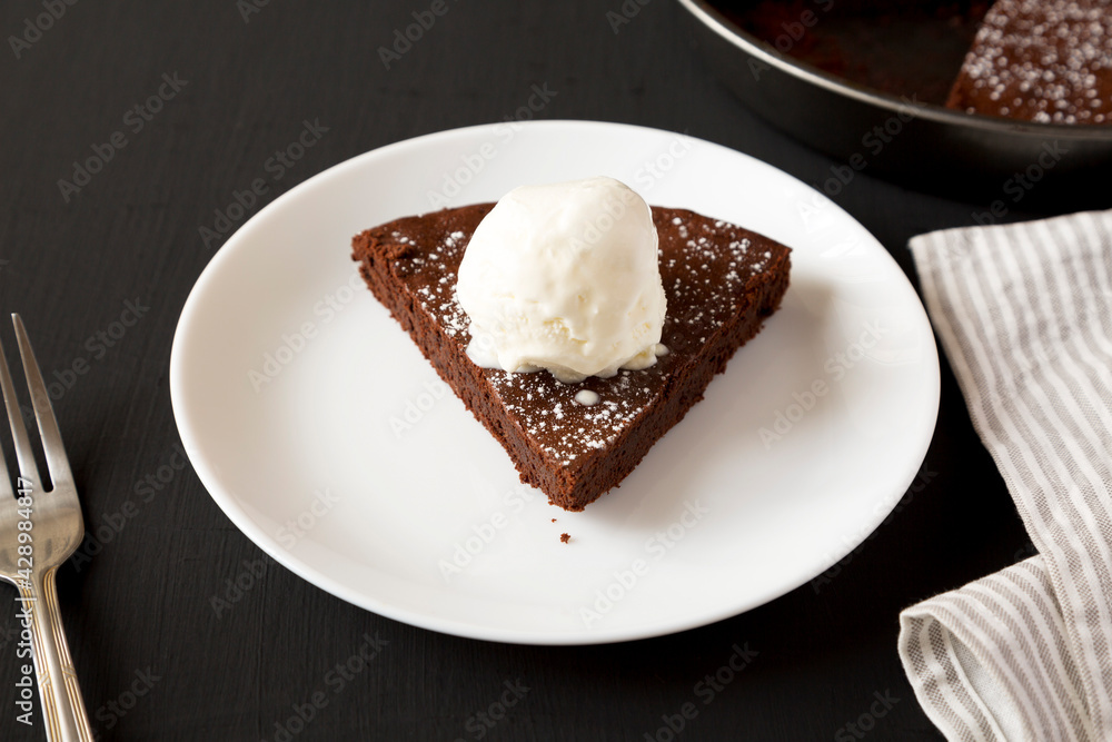 Homemade Chocolate Cake with Ice Cream on a black surface, side view. Homemade Chocolate Cake with Ice Cream on a black surface, side view.