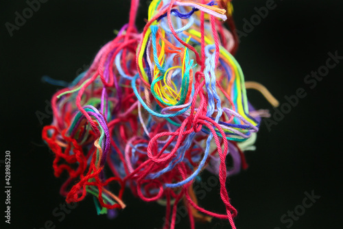 Multicolored tangled threads for needlework on black background