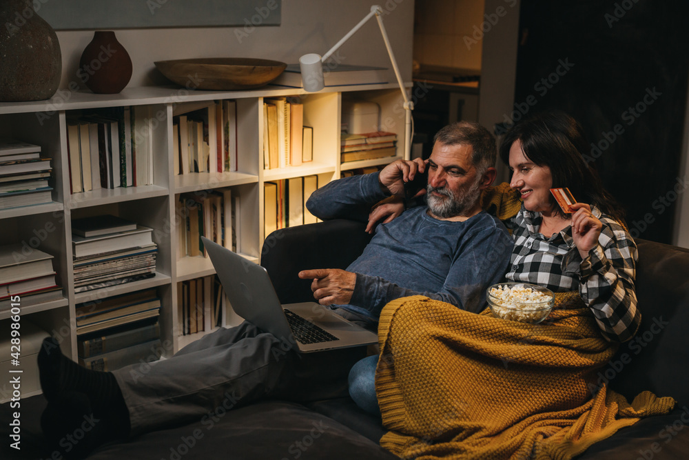 middle age couple enjoying time together at home. they are shopping online middle age couple enjoying time together at home. they are shopping online