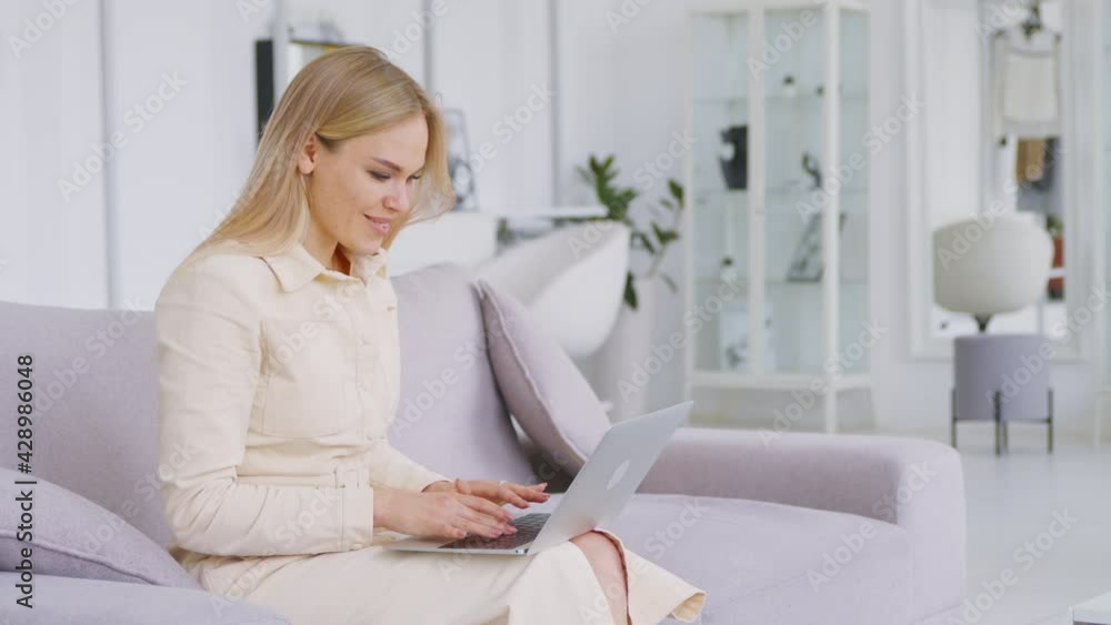 Smiling girl typing message to friends at home. Attractive woman Smiling girl typing message to friends at home. Attractive woman