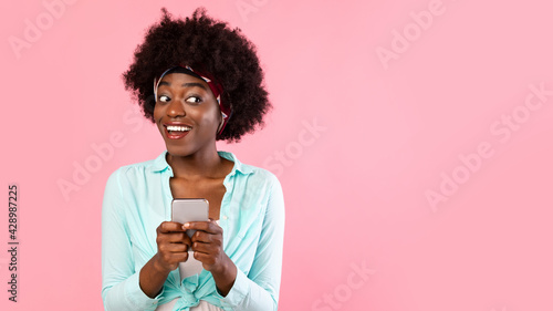 Happy African American Woman Using Mobile Phone Over Pink Background