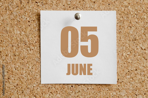 june 05. 05th day of the month, calendar date.White calendar sheet attached to brown cork board.Summer month, day of the year concept photo