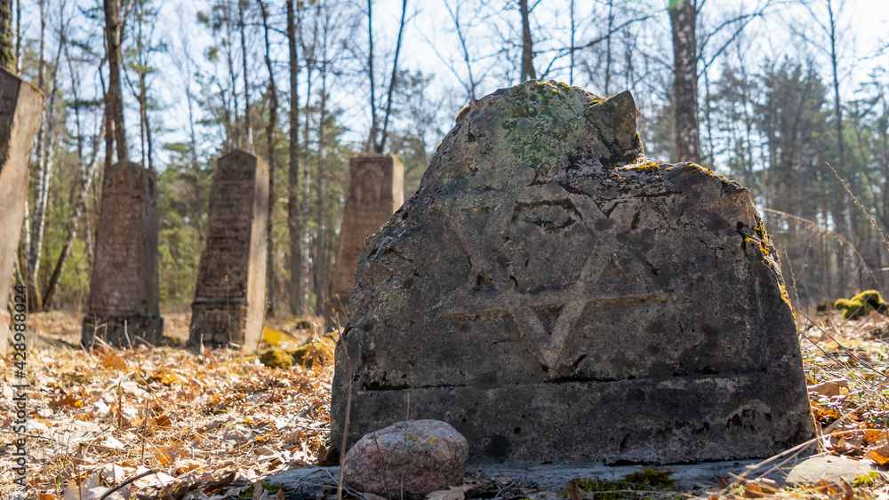 Unique Wooden Jewish matzevah. Jewish Tombstone. Old jewish cemetery in the forest.