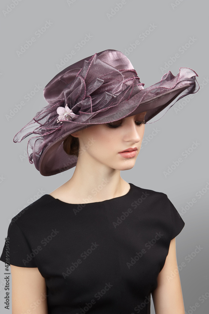 Foto Romantic lady is wearing muted violet hat for evening party