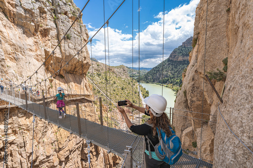 People crossing the suspension bridge in Royal Trail (El Caminito del Rey) in gorge Chorro, Malaga province.