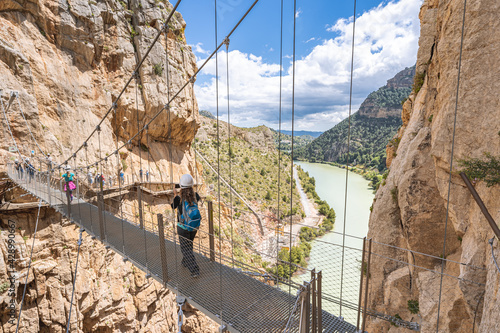People crossing the suspension bridge in Royal Trail (El Caminito del Rey) in gorge Chorro, Malaga province. photo