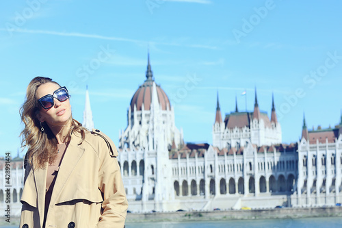 spring girl on the background of the parliament in budapest, sunglasses fashionable european look