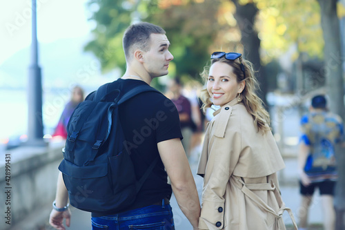 Photography spring walk guy and girl back view, couple walks in the city seasonal view