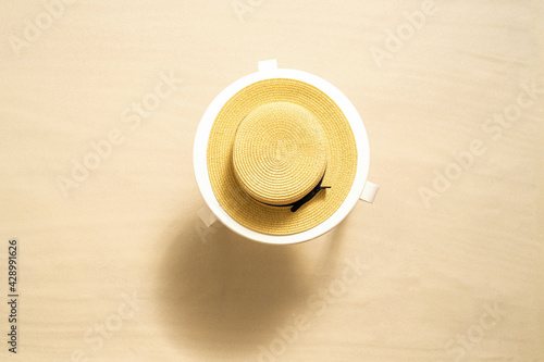 Tableau sur toile Straw hat on the white table on the sandy beach
