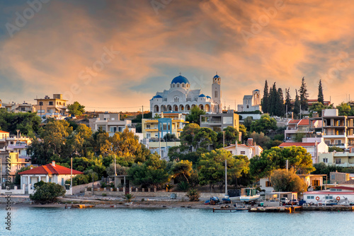 Salamis Island, Attica, Greece. The Assumption of Virgin Mary holy church in Salamis island, as seen from the ferry boat (route Piraeus - Salamis). Sunset, colorful cloudy sky