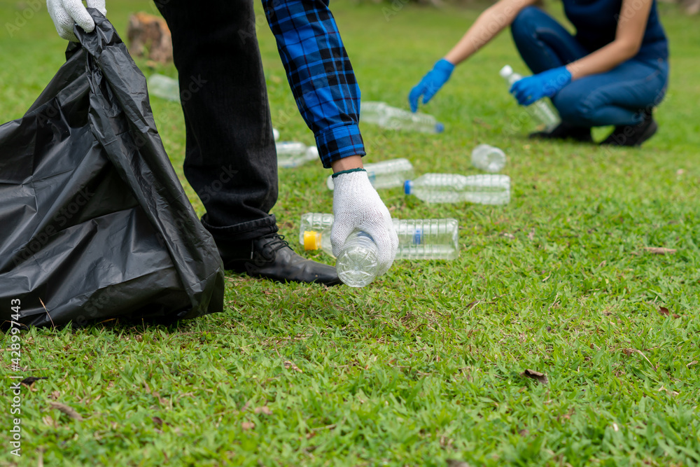 young volunteers collecting garbage in park. Ecology group. Concept of environmental protection. Team with recycle project outside.