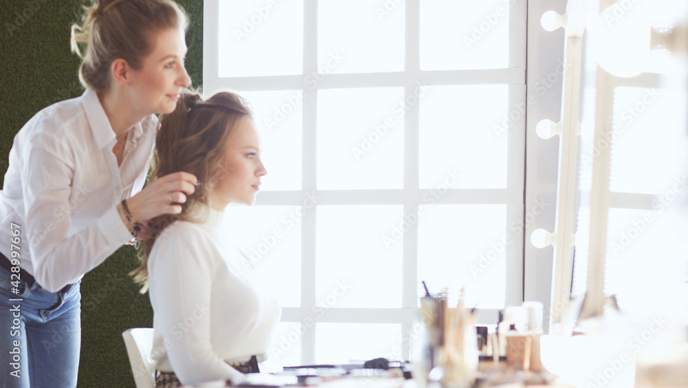 Fototapeta premium make up artist doing professional make up of young woman