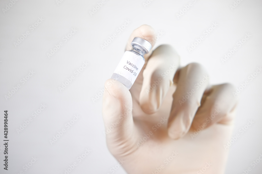 hand in latex gloves holding glass ampoule vaccine, with copy space hand in latex gloves holding glass ampoule vaccine, with copy space