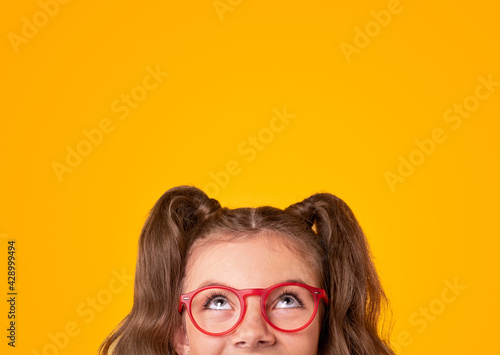 Happy girl in trendy glasses looking up