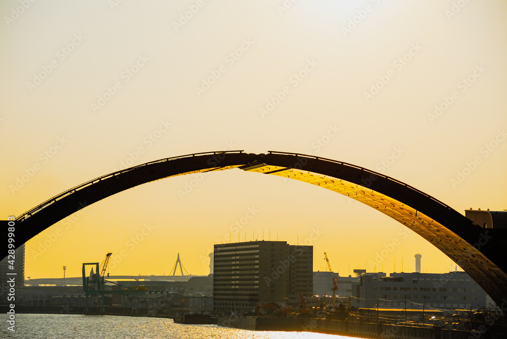 Obraz premium 春の夕陽をうけ黄金色に輝く安治川水門