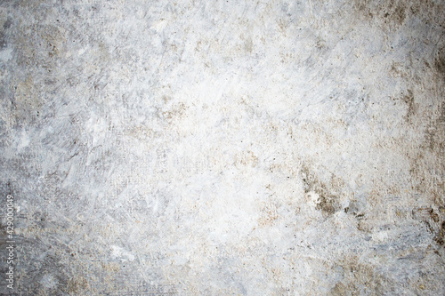 White dirty dusty plain floor surface in a renovated building covered with dust from grinding and painting the walls. White dirty monochrome background.