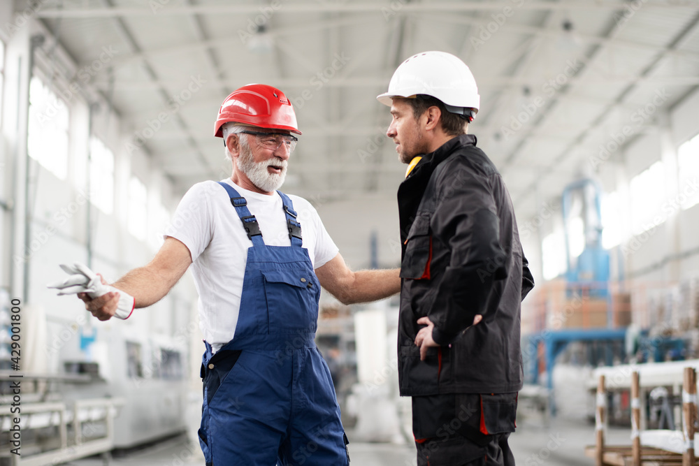 Portrait of workers in factory. Colleagues with helmet working in factory. Portrait of workers in factory. Colleagues with helmet working in factory.