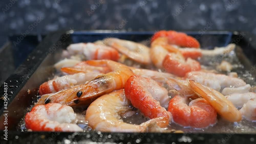 red tiger and common prawns are fried in a baking sheet. dolly shooting. Some of the shrimp are peeled. Slow motion. Close-up