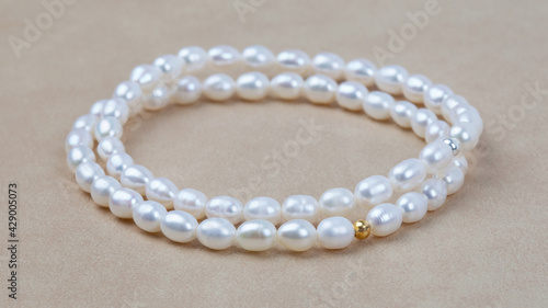 Luxury elegant baroque pearl bracelets on beige textured leather background