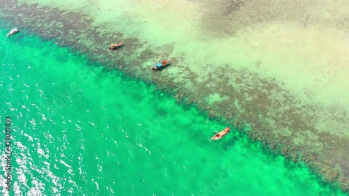 Ko Kradan Island in Thailand. A view of a sunny Thai island, boats with tourists. Paradise island, vacation, blue sky, clear water, Asia, snorkeling, teal, ocean. 4K Drone Footage photo