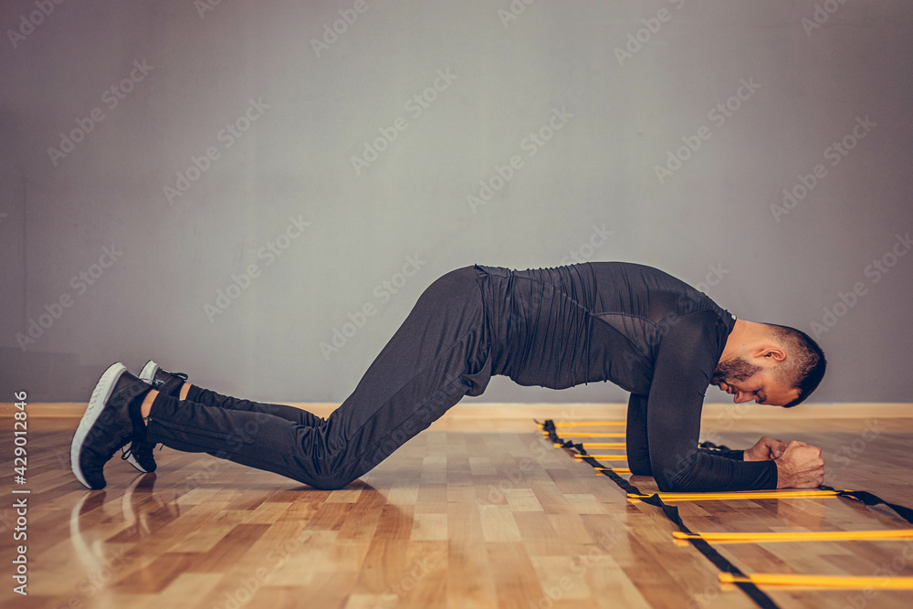 Fitness training athletic sporty man doing plank exercise in gym or home concept. Bearded man exercising workout aerobic at grey background. Fitness training athletic sporty man doing plank exercise in gym or home concept. Bearded man exercising workout aerobic at grey background.