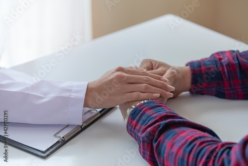 Female doctor touching patient hand for encouragement