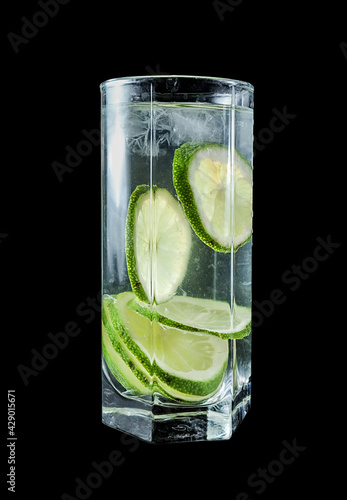 cold lemonade in high transparent glasses with lemons on a black background