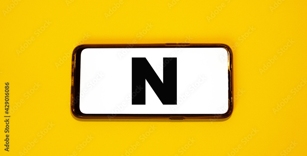 English letter N on white screen of frameless smartphone English letter N on white screen of frameless smartphone