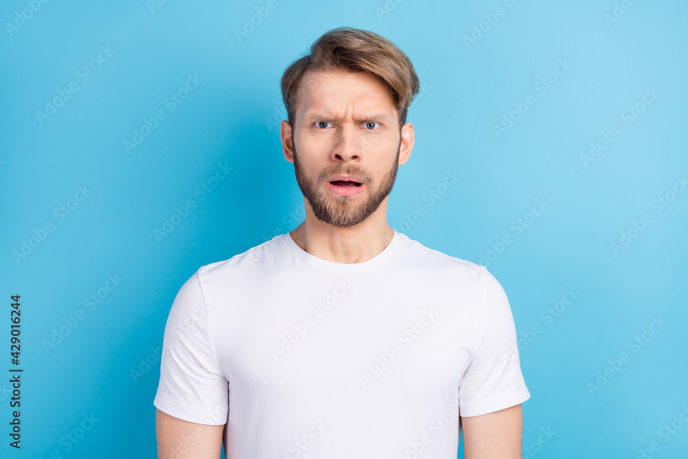 Photo portrait of amazed guy wearing casual t-shirt misunderstanding got problem isolated on vibrant blue color background