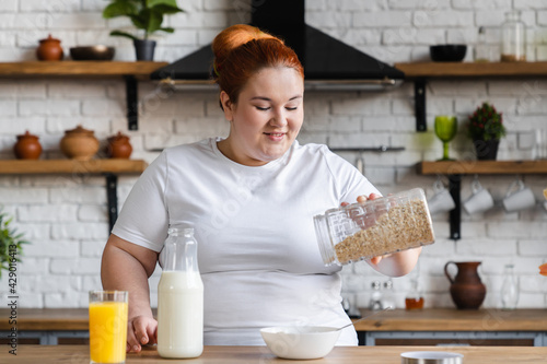 Fotografie Hungry starving fat caucasian woman cooking healthy dieting breakfast