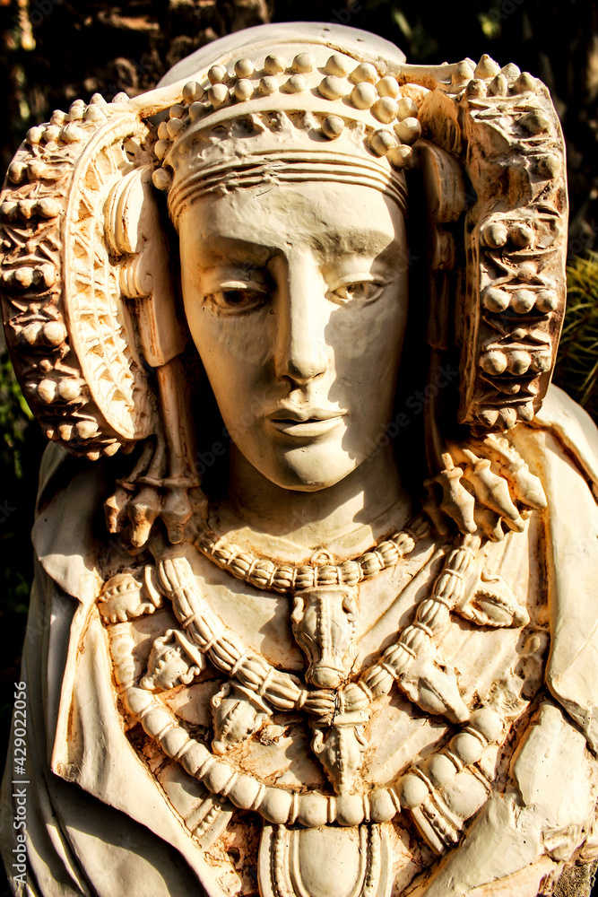 Lady of Elche stone bust in a garden