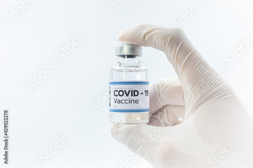 Vaccine concept in the hand of doctor white vaccine jar with copy space. Vaccine Concept of the fight against coronavirus, immunization, and treatment, medical concept, isolated on blue background.