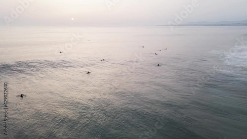 Aerial view of a surfer riding a big waves in Atlantic Ocean open water at sunset along Caparica coastline, Lisbon, Portugal.