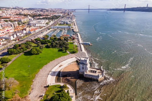 Aerial view of Belem Tower with April 25th bridge and Lisbon Yacht club in background along the Tagus River, Lisbon, Portugal.