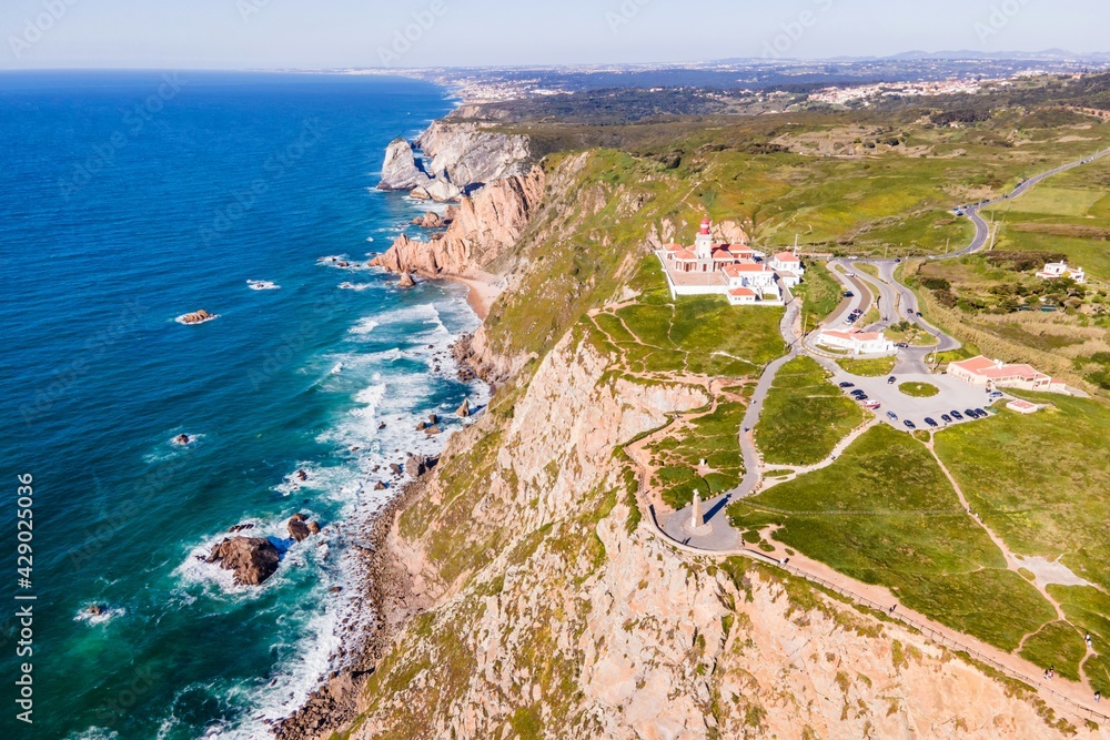 Aerial view of Cabo da Roca lighthouse with majestic coastline looking the Atlantic Ocean, a famous landmark in Colares, Lisbon, Portugal.