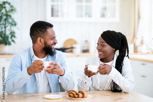 Domestic Morning. Young Happy Black Couple Having Coffee And Croissants For Breakfast